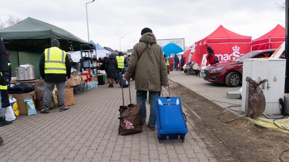 Een man die net de Oekraïense grens naar Polen is overgestoken, trekt zijn bagage door de grensovergang van Medyka. Vanuit Medyka kunnen mensen vervoer krijgen naar elders in Polen of Europa. Bij de grensovergang is het (vanaf 10 maart) erg druk met Poolse en internationale vrijwilligers. Stapels gedoneerde kleding, dekens, speelgoed, babymelk en voedsel voor huisdieren staan langs de ingang van de grens. Bij de grenspost komen voortdurend mensen aan uit en vertrekken weer terug naar Oekraïne.