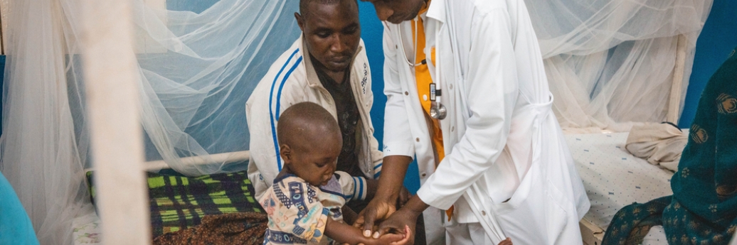 Lors de la visite médicale matinale, un médecin examine les œdèmes sur le corps d’Alice, une patiente admise pour malnutrition aiguë sévère au Centre de récupération nutritionnelle intensive de l’hôpital général de référence de Masisi